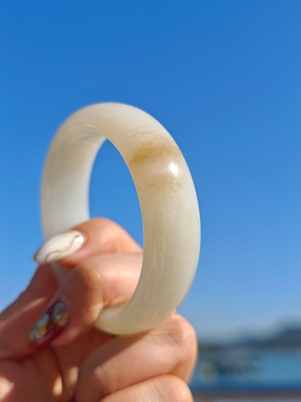 Certificate-certified Hetian white jade bangle with sugar-like inclusions | 56 mm in diameter, 18.4 mm thick.